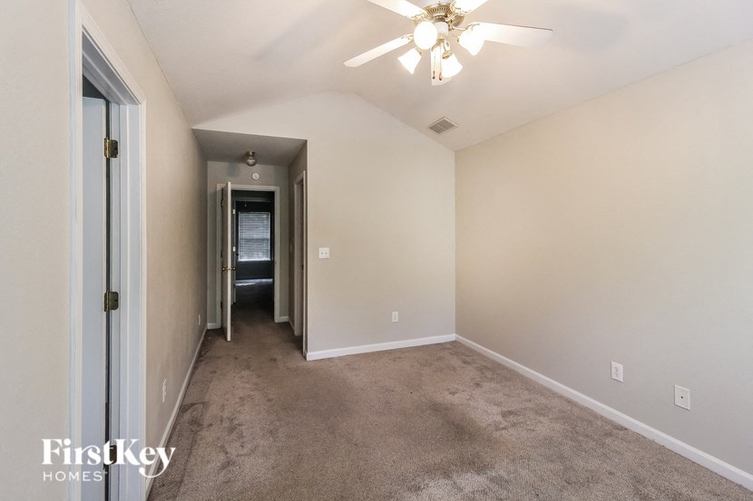 a room with a carpeted floor and a ceiling fan