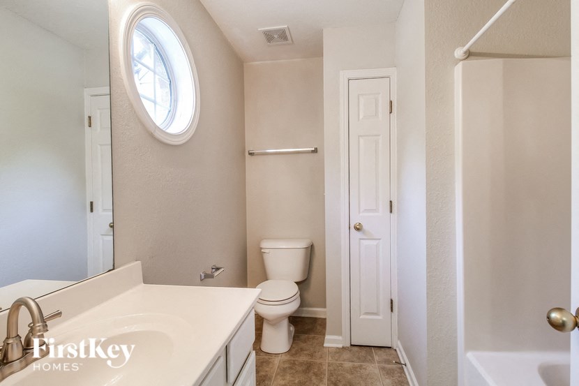 a bathroom with a toilet and a sink and a window