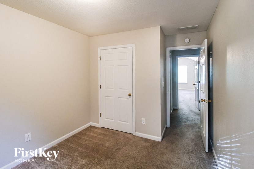 a living room with a white door and a hallway to a closet