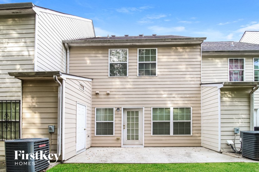 a white house with tan siding and a sidewalk