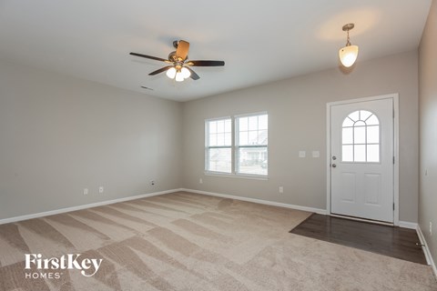 a living room with a ceiling fan and a white door
