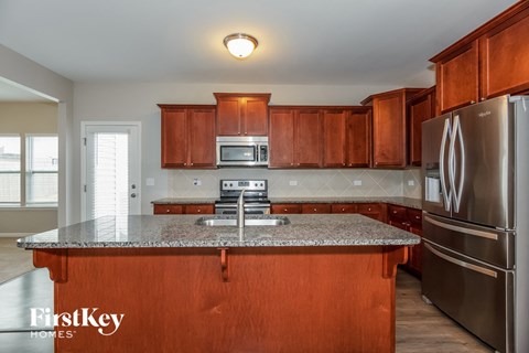 full view of kitchen with granite counter tops and wooden cabinets