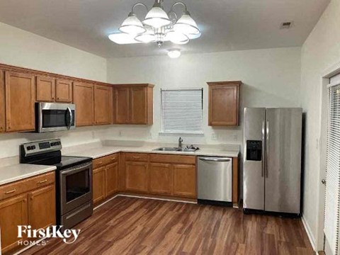a kitchen with wooden cabinets and a stainless steel refrigerator