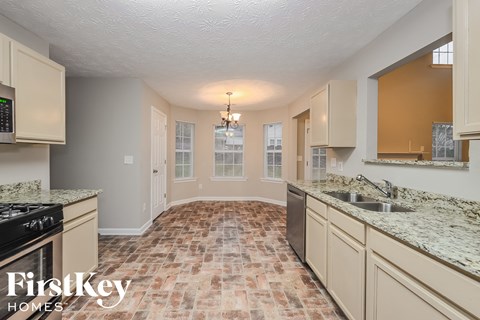 A kitchen with a tile floor and a stove top oven.
