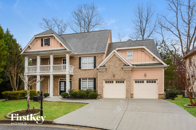 A brick house with a garage and a porch.
