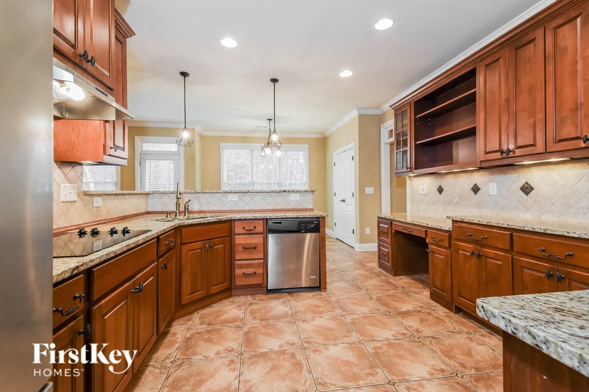 A kitchen with brown cabinets and a tiled floor.