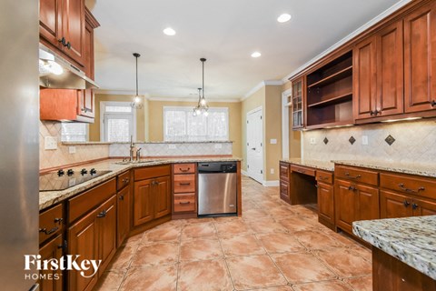 A kitchen with brown cabinets and a tiled floor.