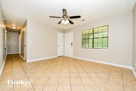 A spacious room with a ceiling fan and a window.