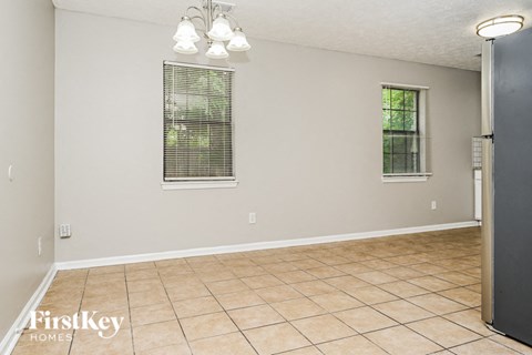A room with a tile floor and a window with blinds.
