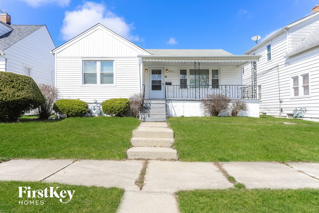 A white house with a porch and a small front yard.