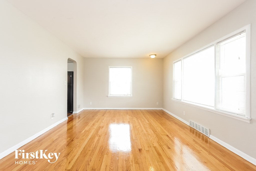 A room with wooden floors and two windows.