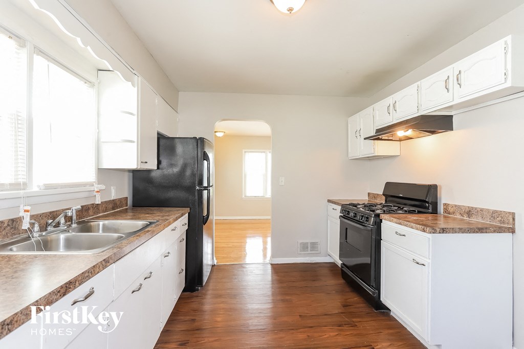 A kitchen with black appliances and white cabinets.