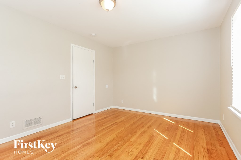 A room with wooden flooring and a white door.