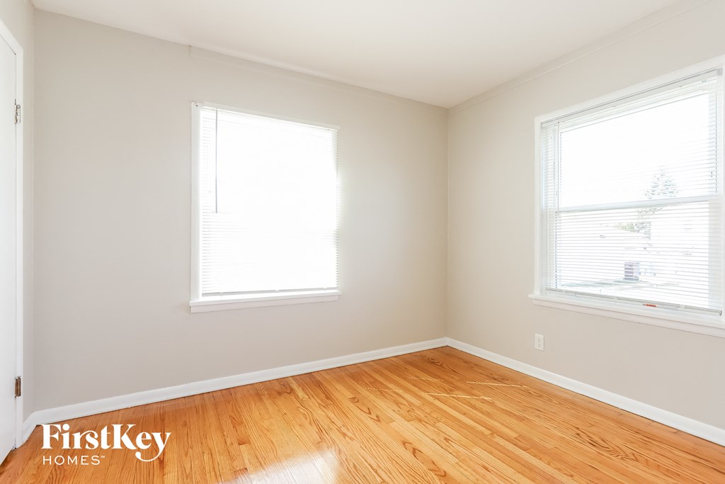 A room with wooden floors and two windows.