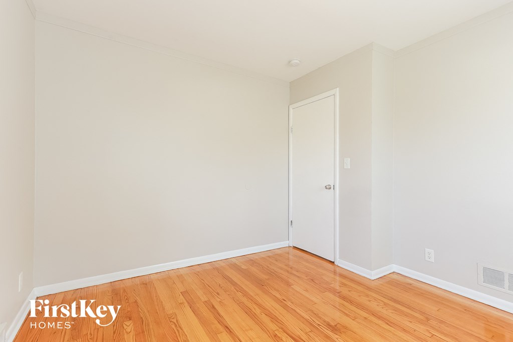 A room with wooden floors and a white door.