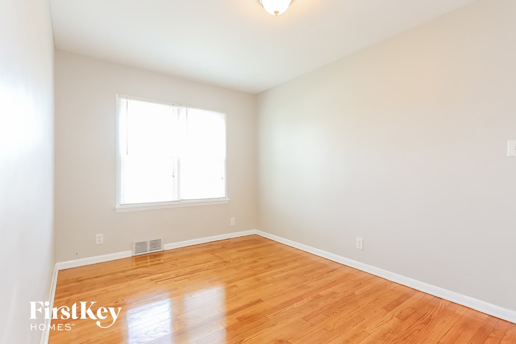 A room with wooden floors and a window letting in light.