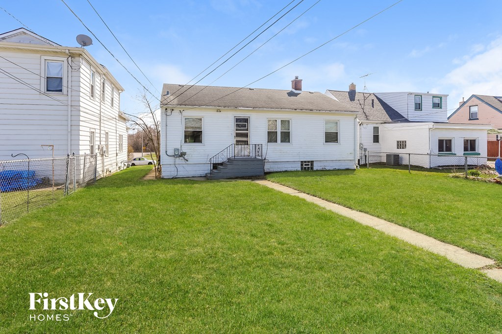 A white house with a green lawn in front of it.