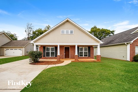 the front of a house with a lawn and a driveway