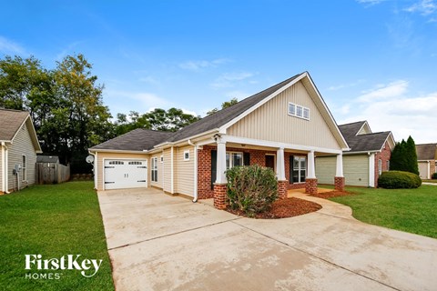 the front of a house with a driveway and a garage door