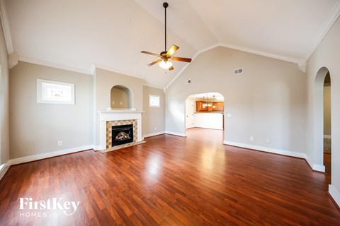 an empty living room with wood flooring and a fireplace