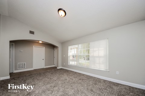 the living room of an empty house with a large window