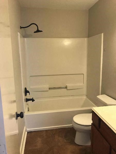 a white bathroom with a toilet and a bath tub
