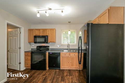 A kitchen with wooden cabinets and black appliances.