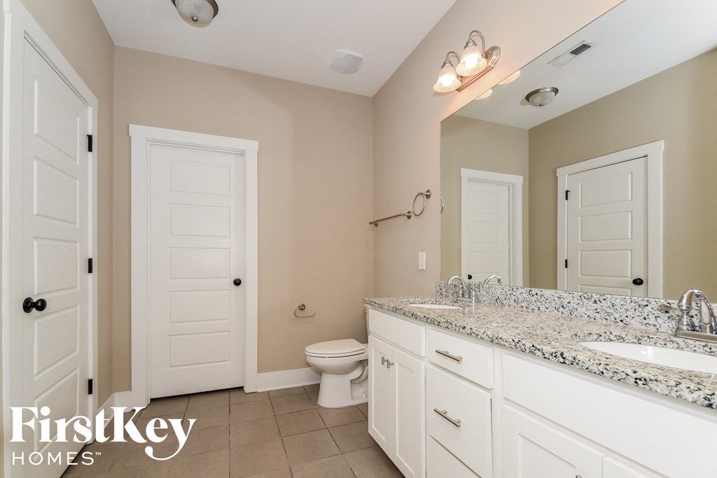 a bathroom with a toilet and a sink and a mirror