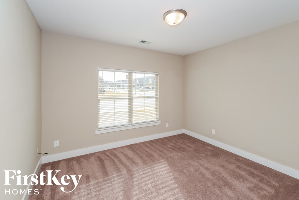 a bedroom with a carpeted floor and a window