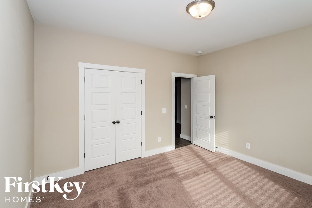a master bedroom with two closets and a carpeted floor