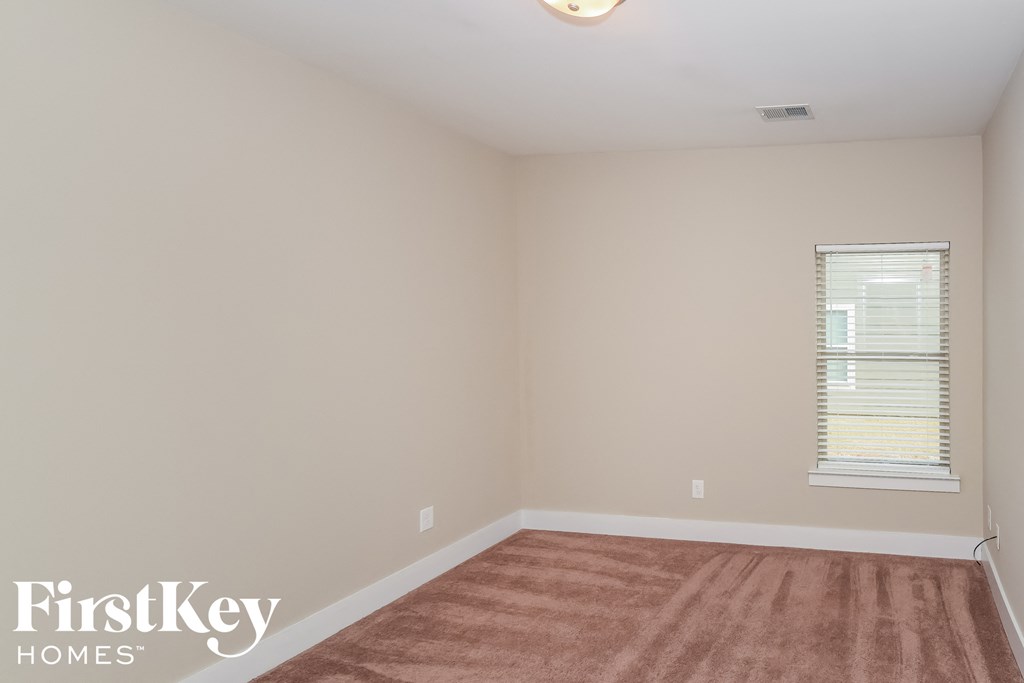 a empty room with a rug and a window