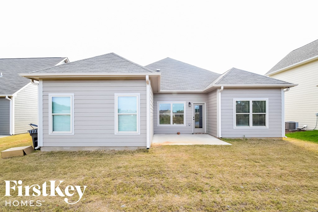 a white house with blue shutters and a front yard