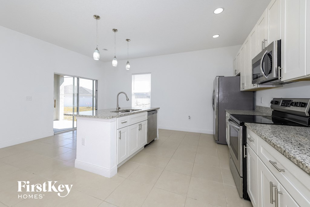 a kitchen with white cabinets and stainless steel appliances and a white counter top