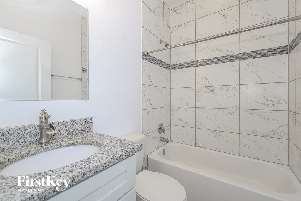 a white bathroom with a sink and a tub and a toilet