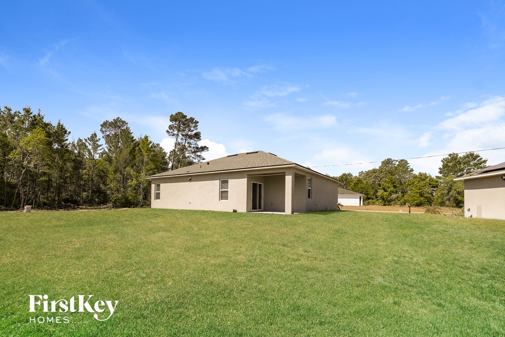 a home with a large yard and a house in the background