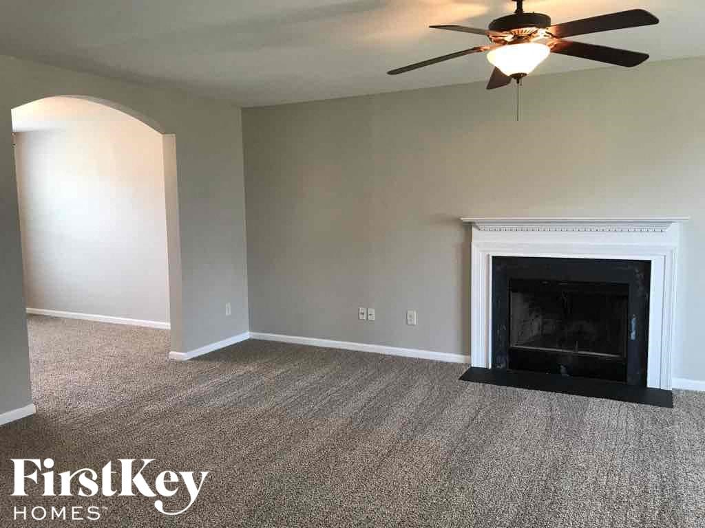 A room with a fireplace and a ceiling fan.