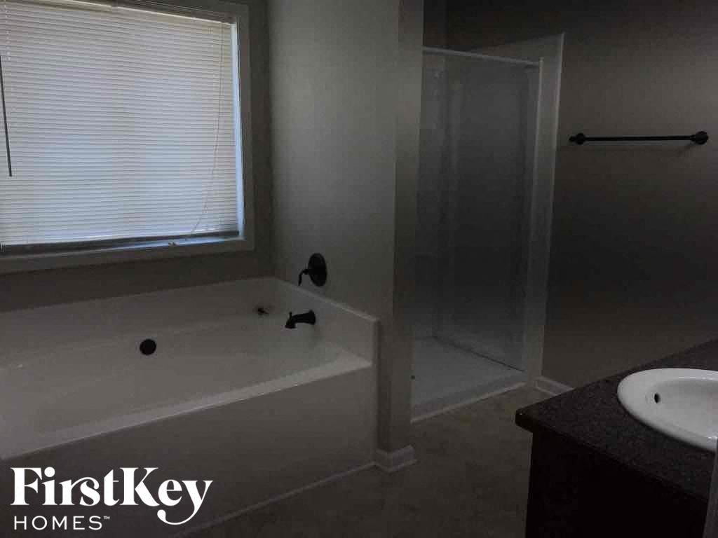 A bathroom with a tub, sink and shower.