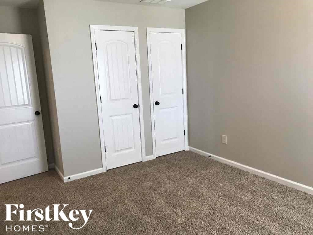A room with two white doors and a carpeted floor.