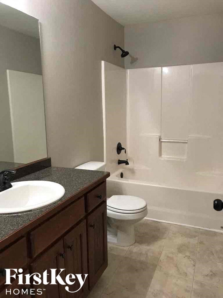 A bathroom with a toilet, sink, and shower.