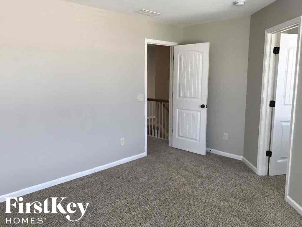 A room with a carpeted floor and a white door.