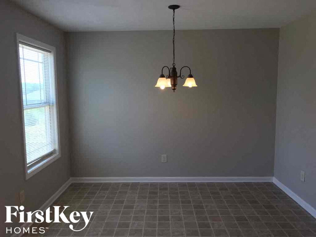 A room with a chandelier and a window.