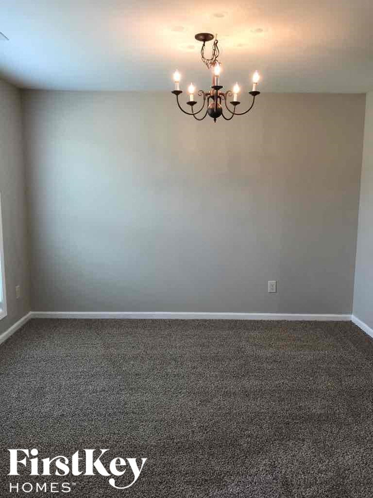 A room with a chandelier and a carpeted floor.