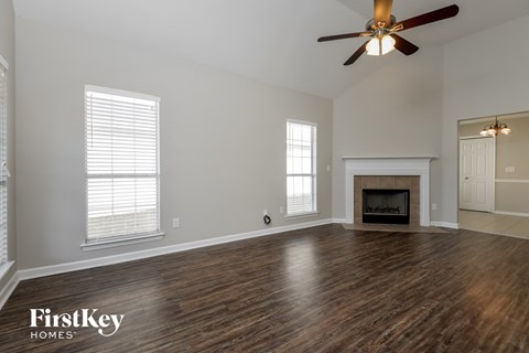 the living room with wood flooring and a fireplace