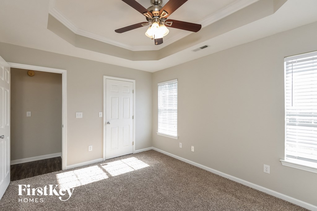 a living room with a ceiling fan and a door