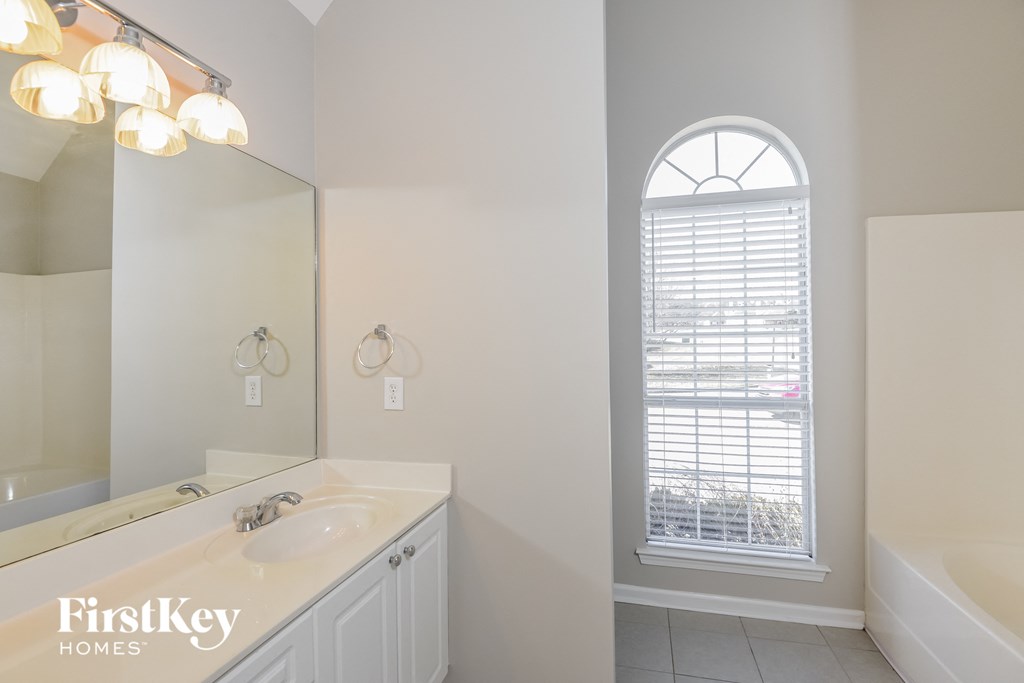 a bathroom with a sink and a mirror and a window