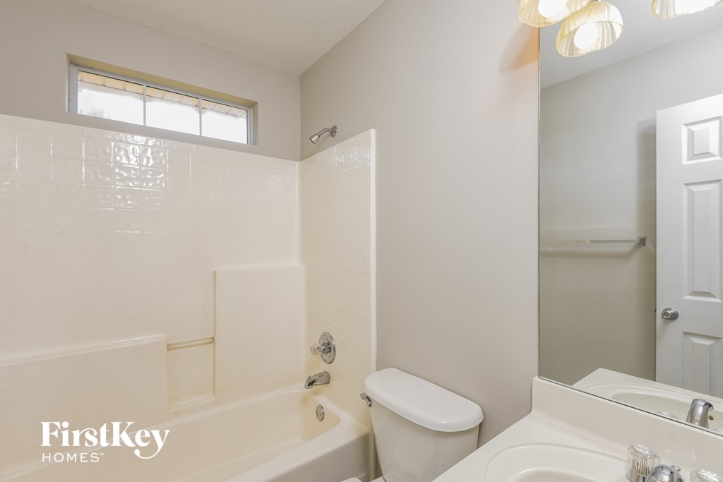 a bathroom with a toilet and a tub and a sink