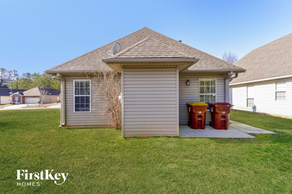 a small house with two trash cans in front of it