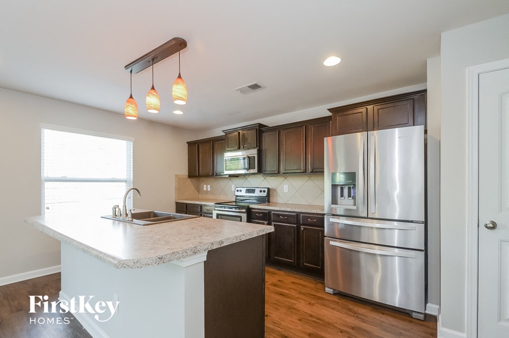 a kitchen with stainless steel appliances and a marble counter top