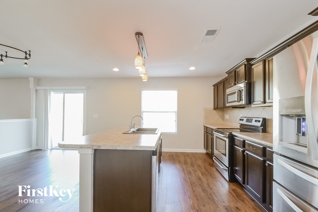 a kitchen with stainless steel appliances and a marble counter top