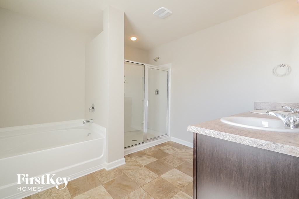 a bathroom with a sink and a tub and a shower
